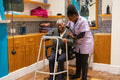 Nurse helping woman with mobility walker in hair salon