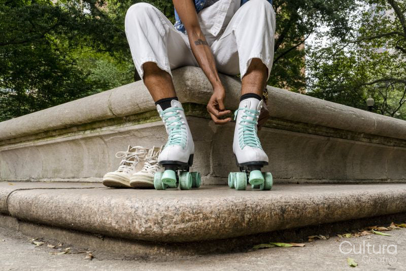 Legs of woman putting on roller skates in park