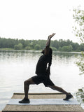Man practicing yoga by lake