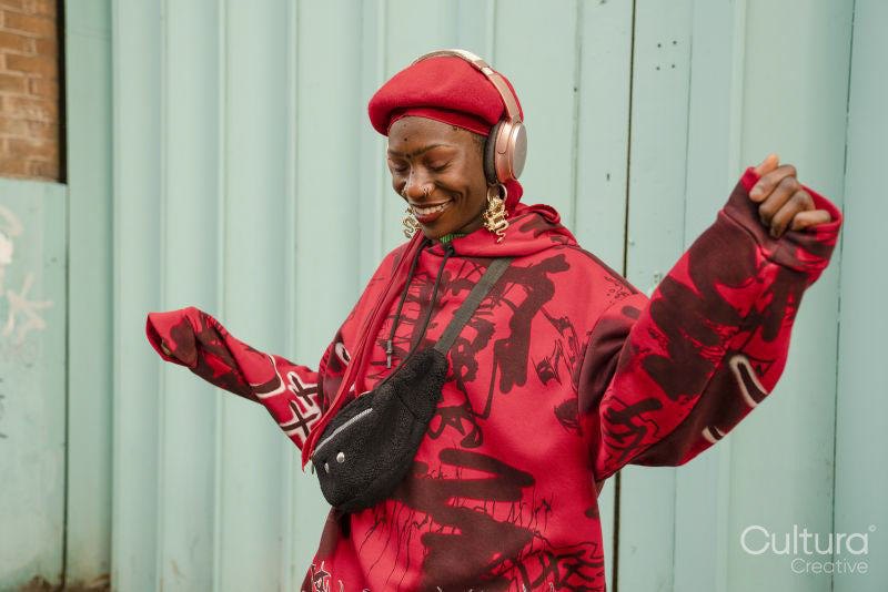 Smiling young woman wearing red dancing outdoors