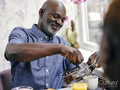Smiling man pouring coffee at breakfast table