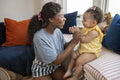 Mother playing with baby daughter at home