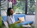 Woman sitting on sofa using smart phone
