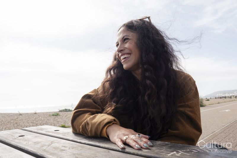 Smiling woman looking away while sitting by picnic table