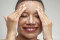 Close-up of smiling woman washing face