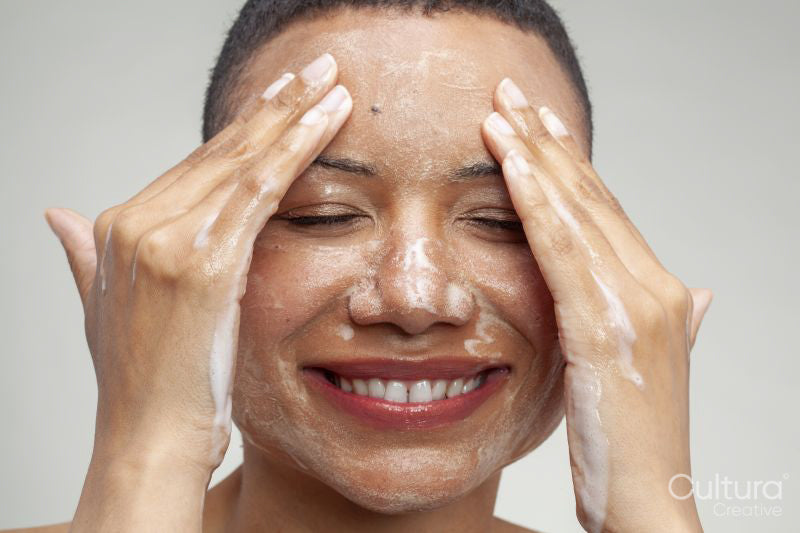 Close-up of smiling woman washing face