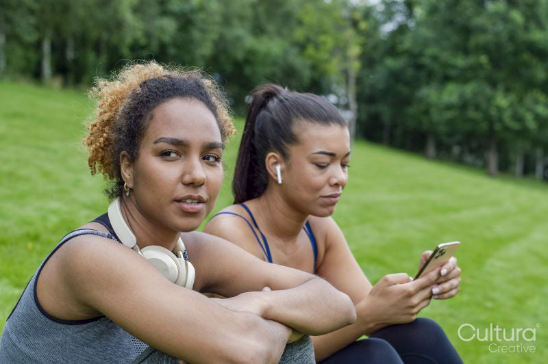 Women in sportswear sitting on lawn