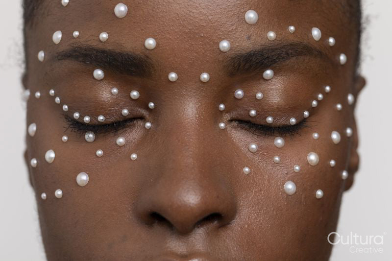 Young woman with closed eyes, wearing pearl freckles