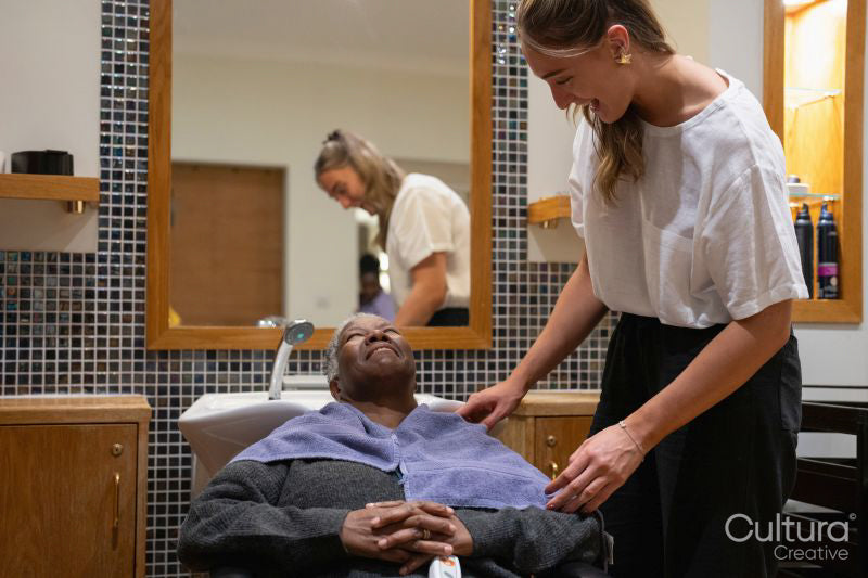 Smiling senior woman and hairdresser in hair salon