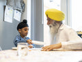 Grandfather and grandson in traditional clothing setting table