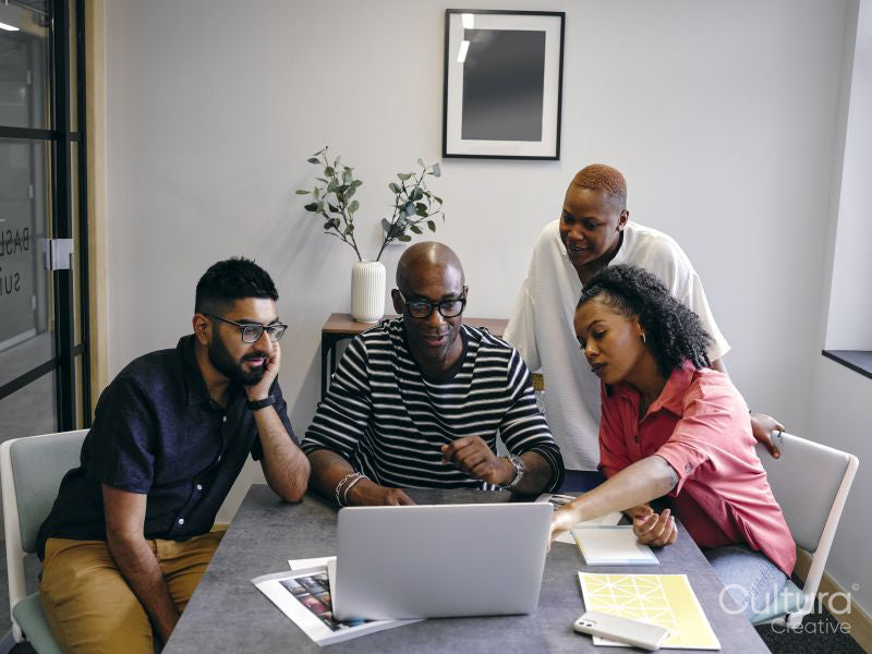 Colleagues looking at laptop during business meeting
