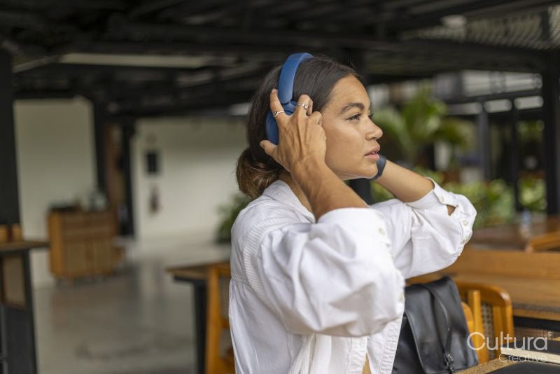 Woman sitting in hotel lounge and using headphones